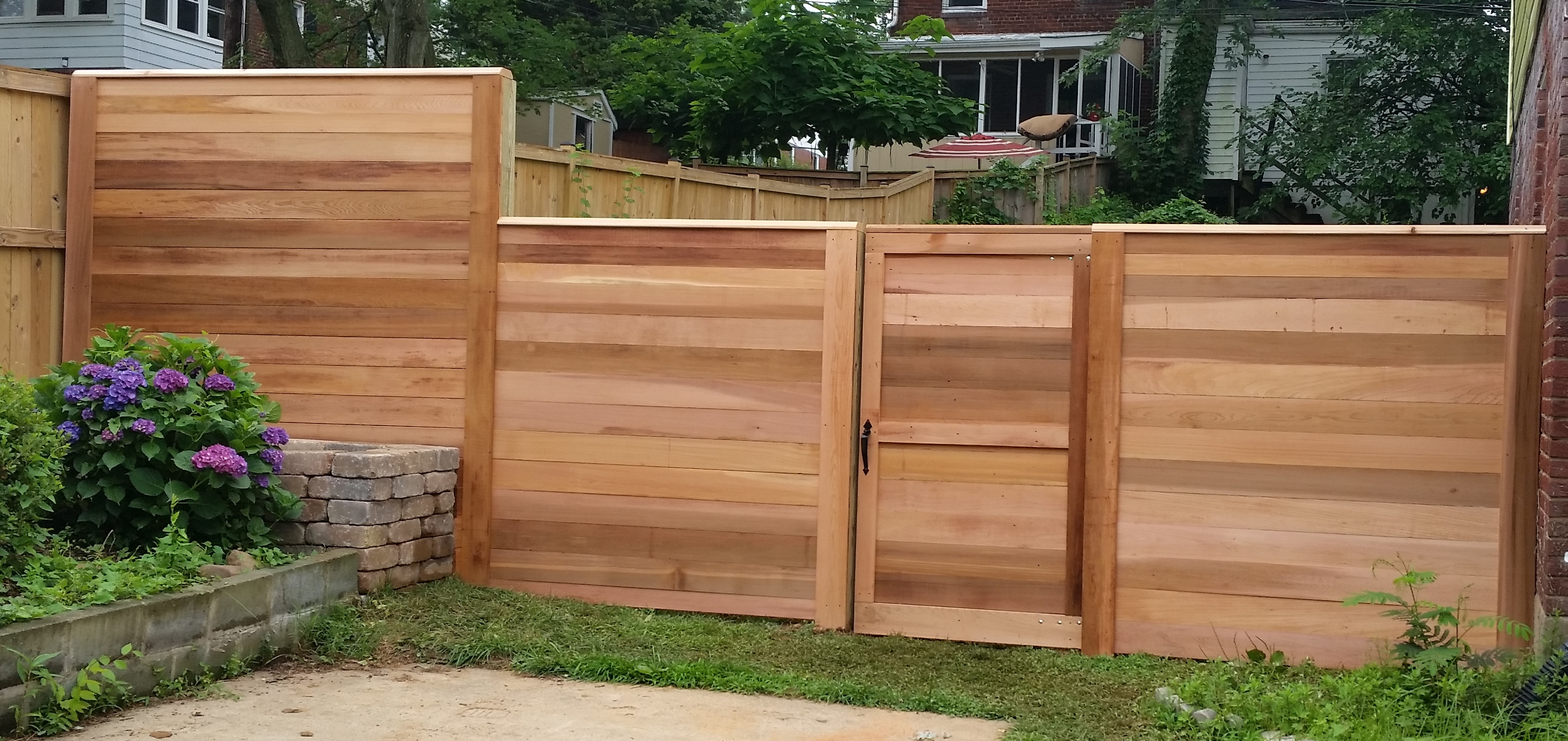 A Flat Board Fence in Clear Western Red Cedar with a 2x4 Cap Board, and no Post Caps.