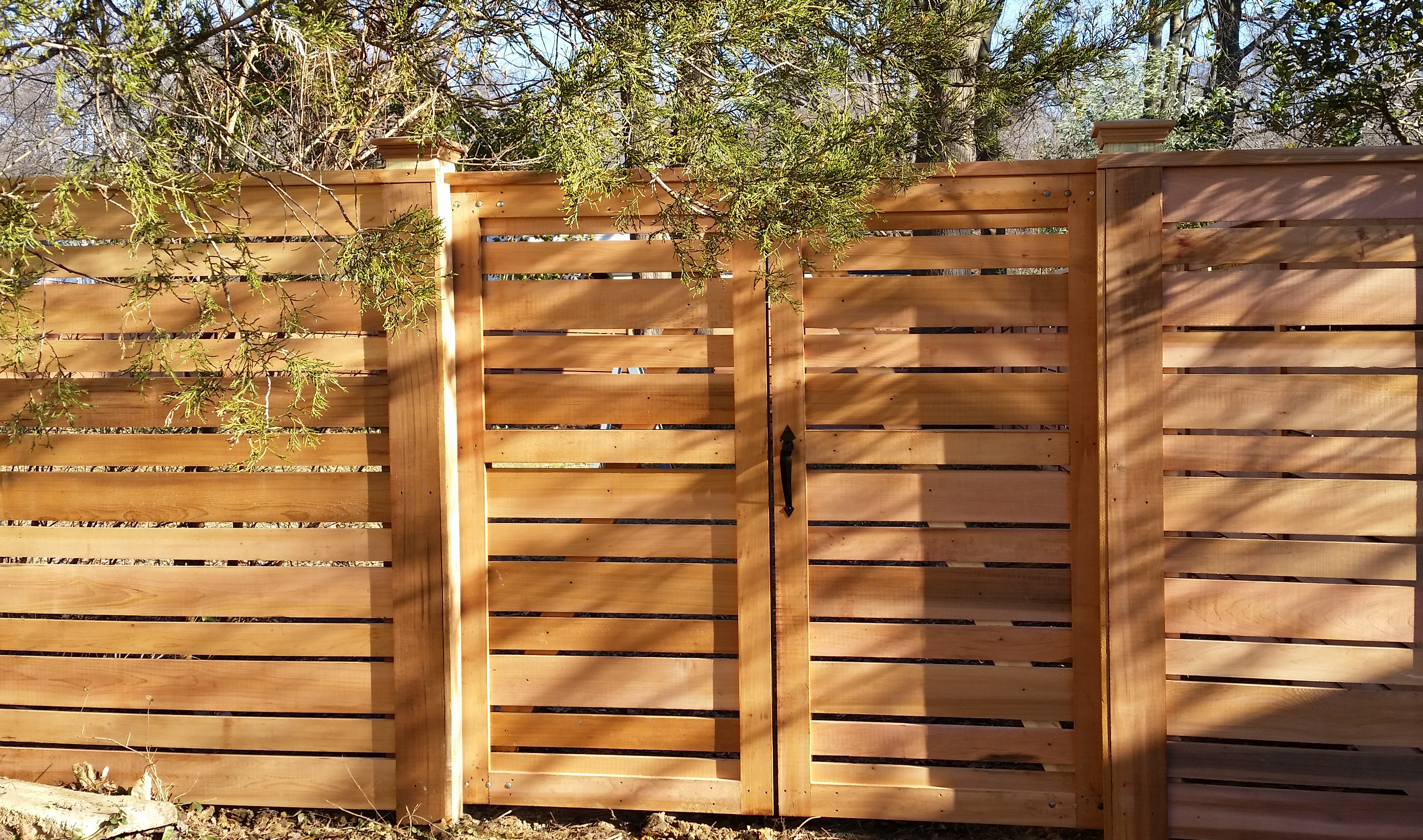 A Semi-Private Fence in Clear Western Red Cedar with a Double Gate, 2x4 Cap Board and Cedar Flat Top Post Caps.